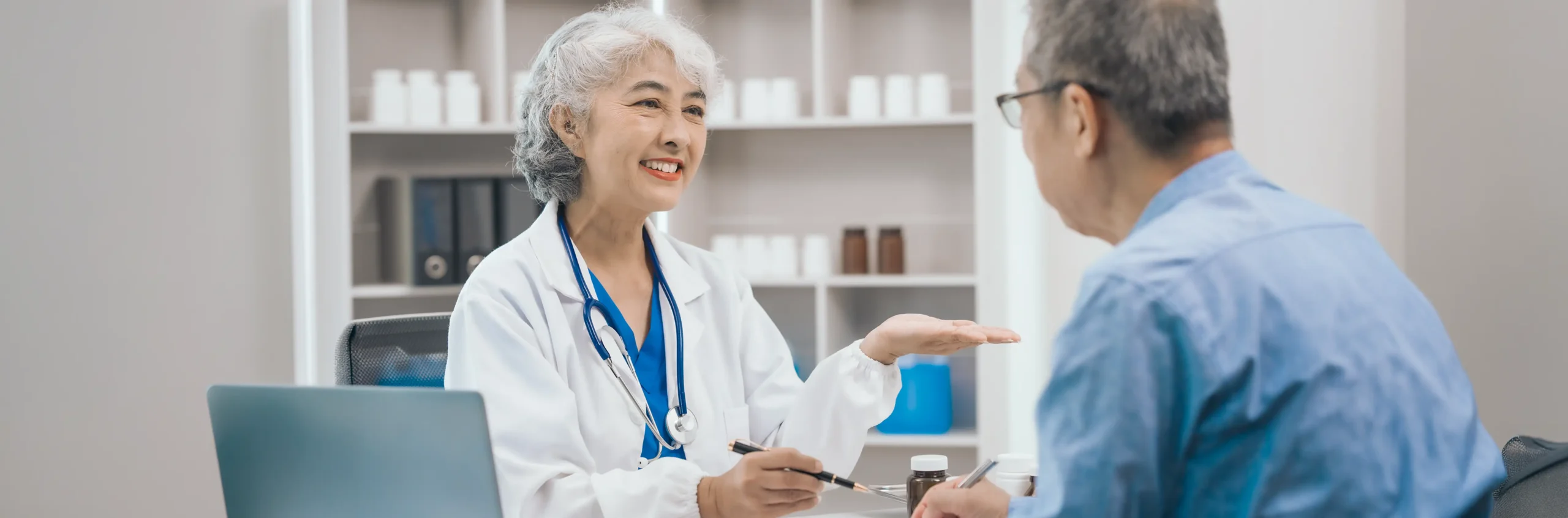 Dentist explaining implant denture options to a patient at a consultation.