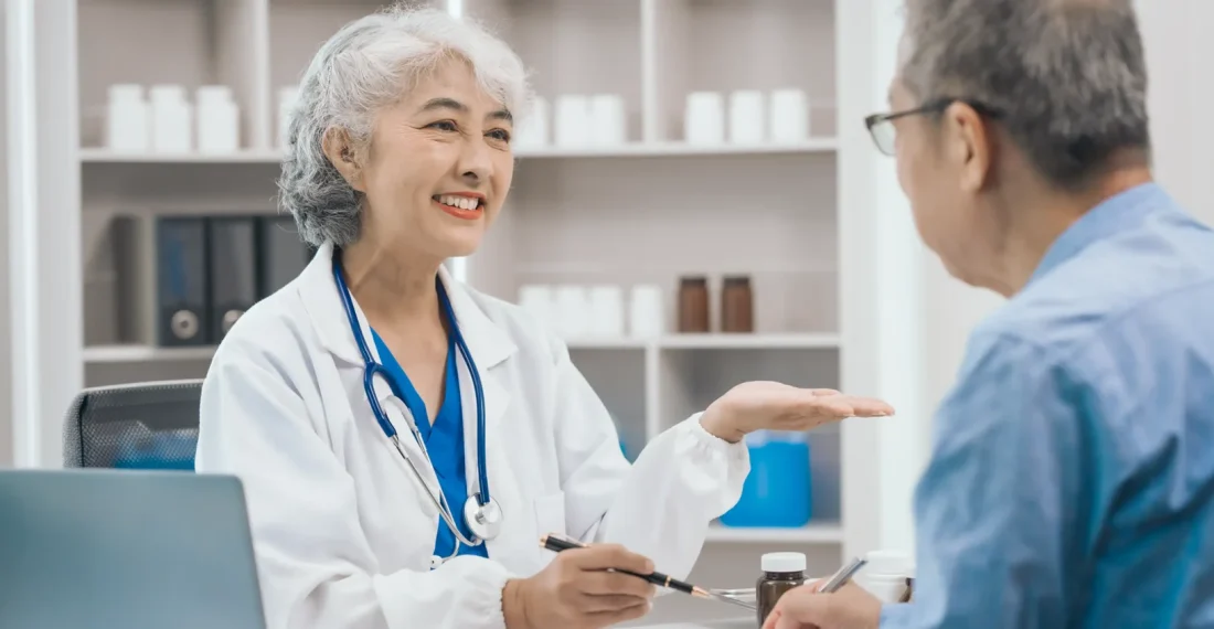 Dentist explaining implant denture options to a patient at a consultation.