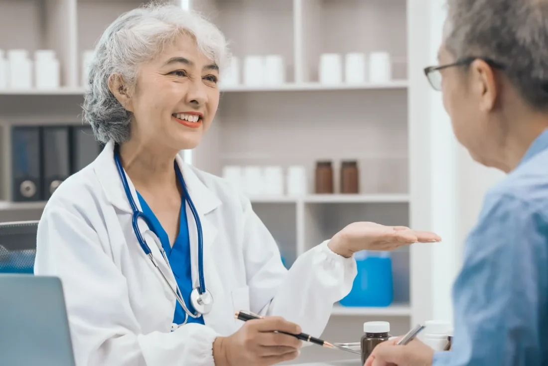 Dentist explaining implant denture options to a patient at a consultation.